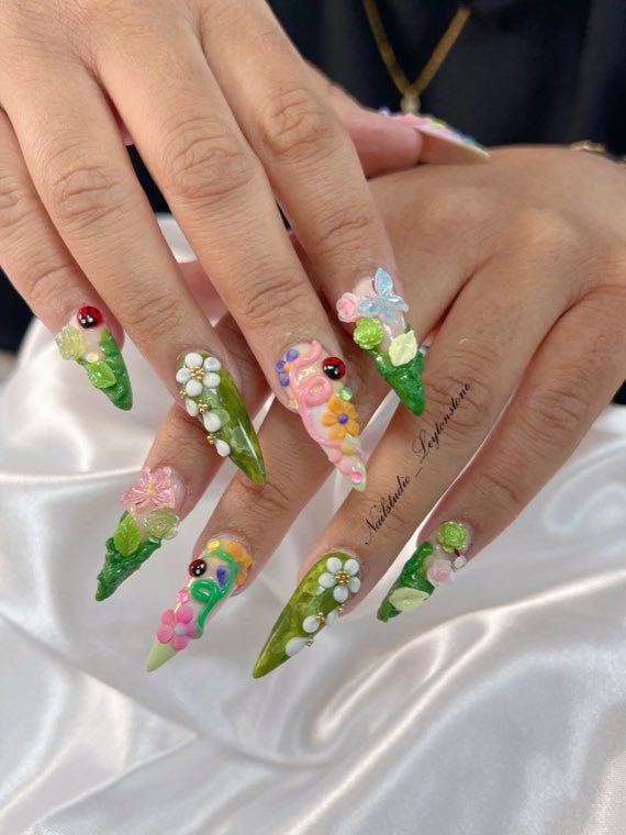 Green stiletto nails with 3D sculpted flowers, ladybirds and gems